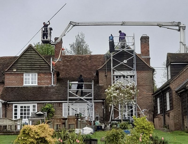 The Roof Moss Cleaners using cherry picker and scaffolding to clean roof safely and professionally in Lightwater, Surrey